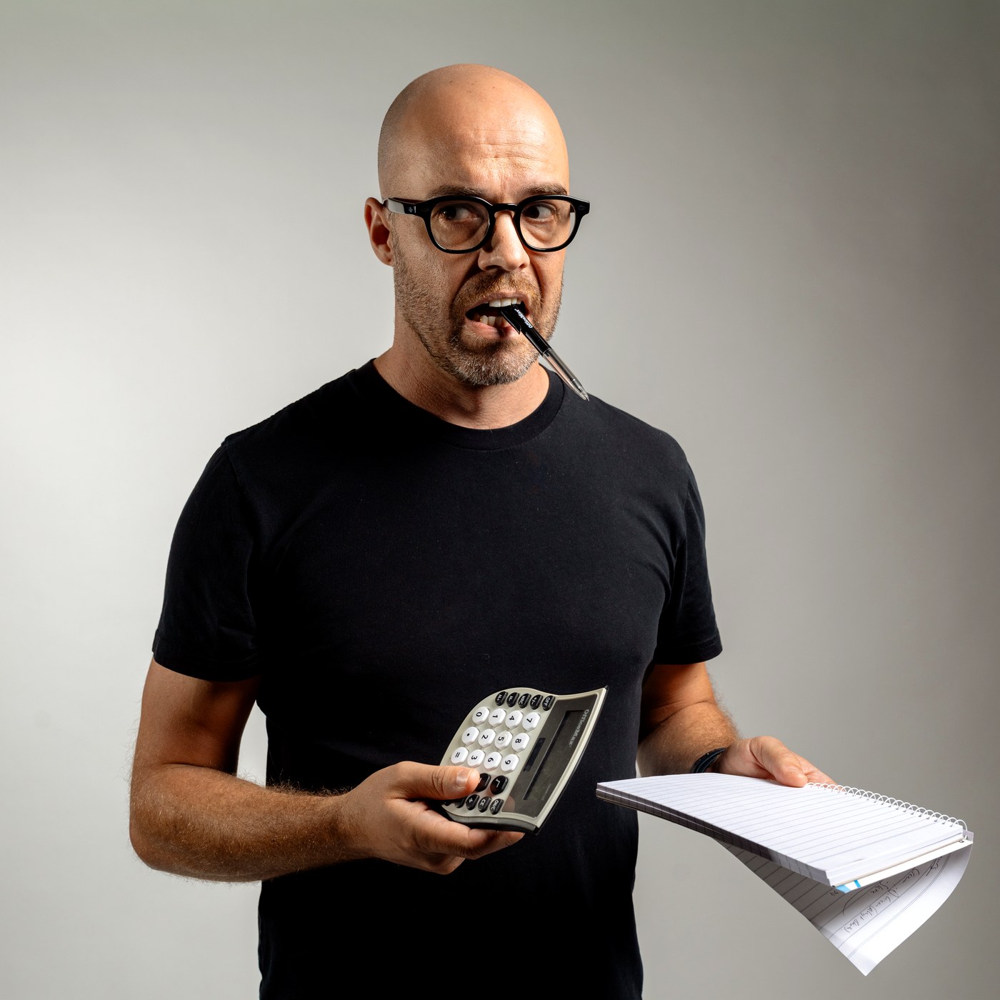 Reagan White holding calculator and notepad for Where's My Money NZ finance podcast